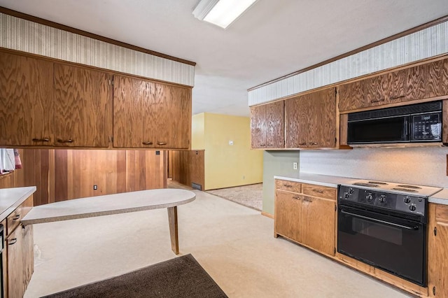 kitchen featuring brown cabinetry, light countertops, light colored carpet, and black appliances
