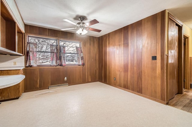unfurnished room with wooden walls and a ceiling fan