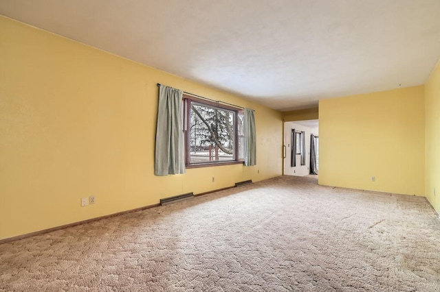 carpeted empty room with visible vents and baseboards