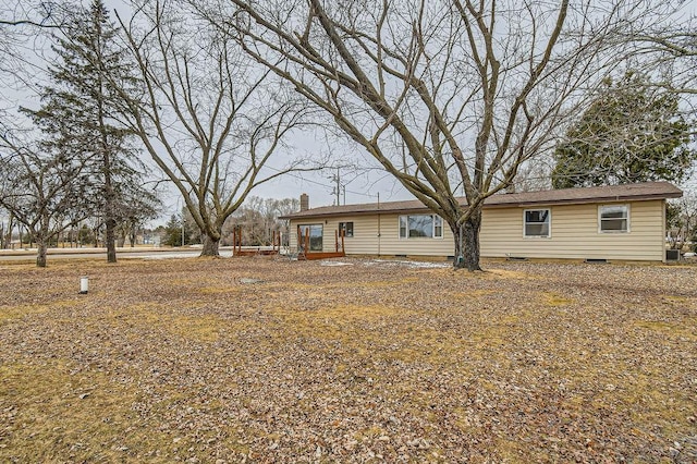 back of property with a chimney and crawl space
