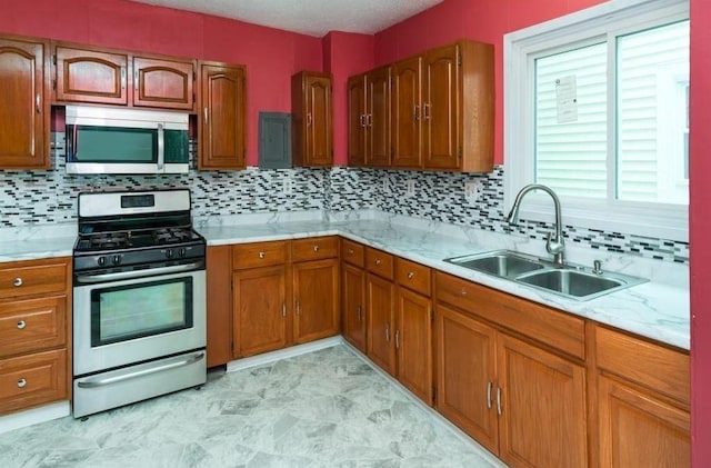 kitchen with appliances with stainless steel finishes, sink, and decorative backsplash