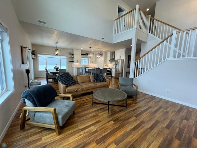 living room with a towering ceiling and hardwood / wood-style floors