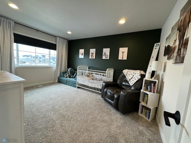 carpeted bedroom featuring a nursery area