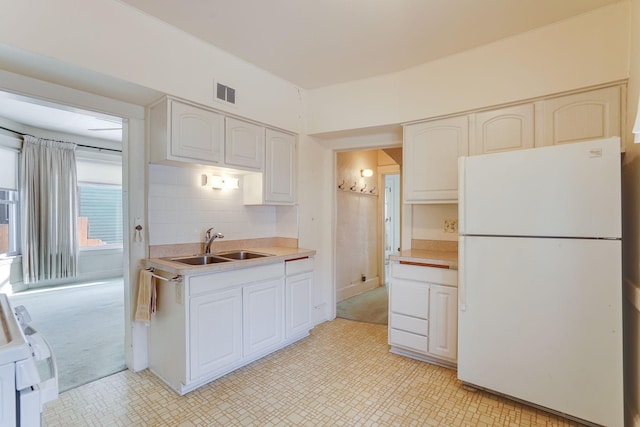 1802 3rd Ave N, Minneapolis, MN 55405 - kitchen featuring sink, white cabinetry, range, white fridge, and backsplash
