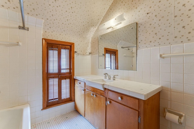 1802 3rd Ave N, Minneapolis, MN 55405 - bathroom with tile patterned flooring, vanity, lofted ceiling, and tile walls