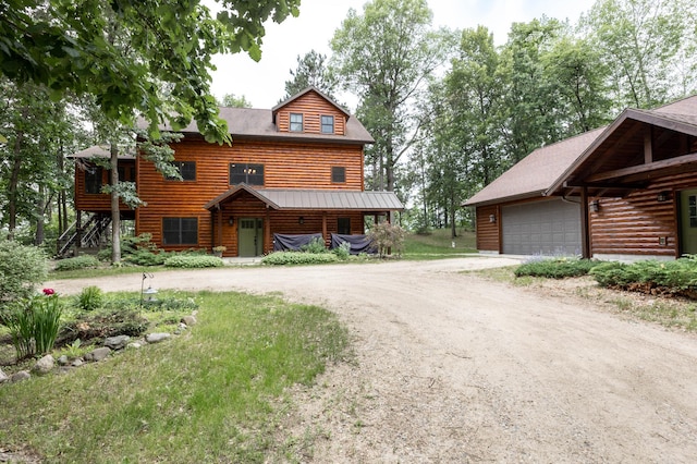 log-style house with a garage and an outdoor structure