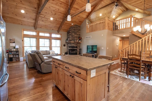 kitchen featuring wood ceiling, hardwood / wood-style flooring, hanging light fixtures, a center island, and beamed ceiling