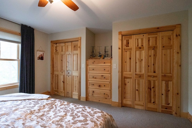 carpeted bedroom with multiple closets and ceiling fan