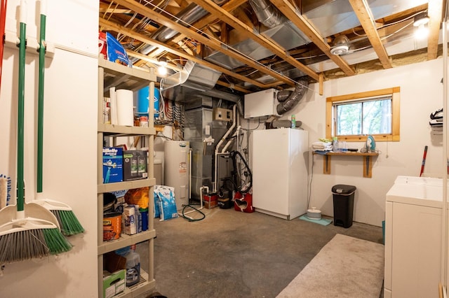 basement with electric water heater, washer and dryer, and white fridge