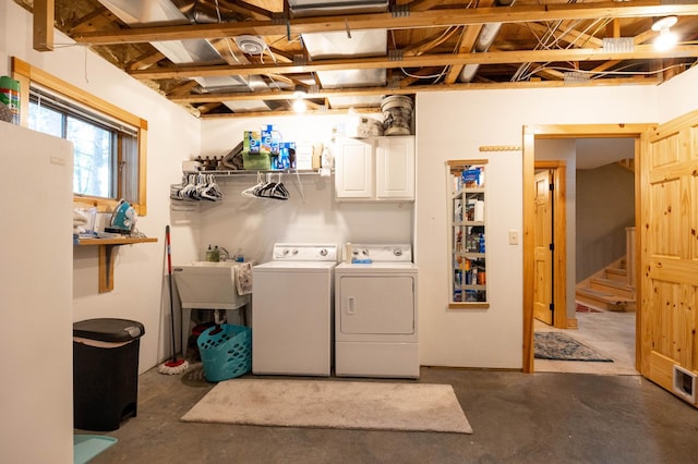 washroom with sink, cabinets, and washing machine and clothes dryer