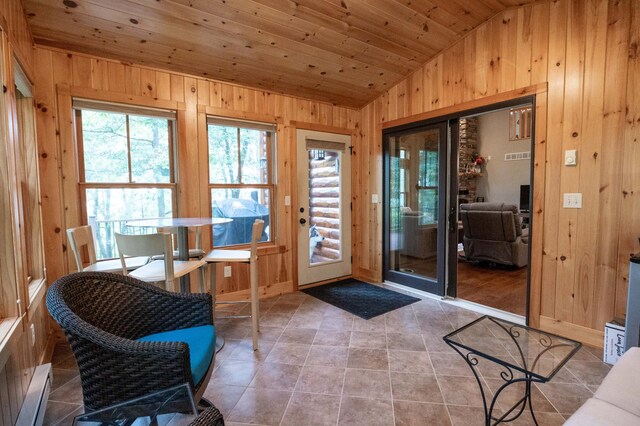 entryway with vaulted ceiling, plenty of natural light, wood ceiling, and wooden walls