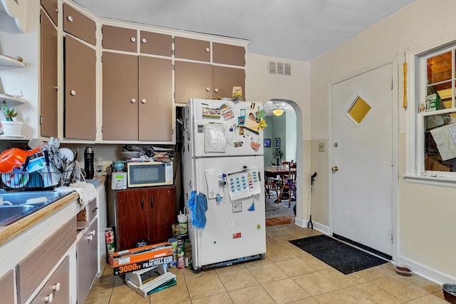 kitchen with white appliances and light tile patterned floors