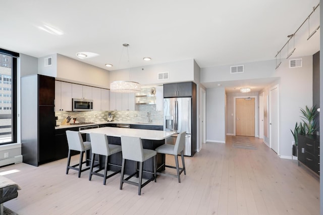 kitchen featuring stainless steel appliances, a kitchen breakfast bar, and visible vents