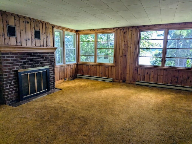 unfurnished living room featuring a baseboard heating unit, plenty of natural light, and carpet