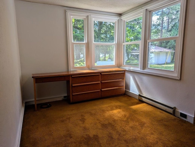 unfurnished room with plenty of natural light, a textured ceiling, dark carpet, and baseboard heating