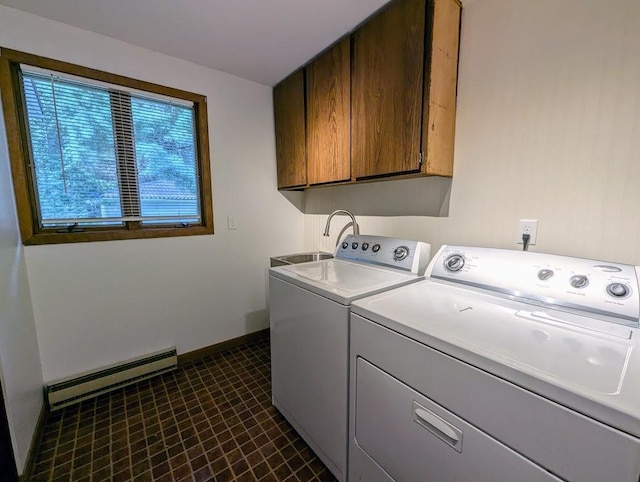 washroom featuring a baseboard heating unit, cabinets, sink, and washing machine and clothes dryer