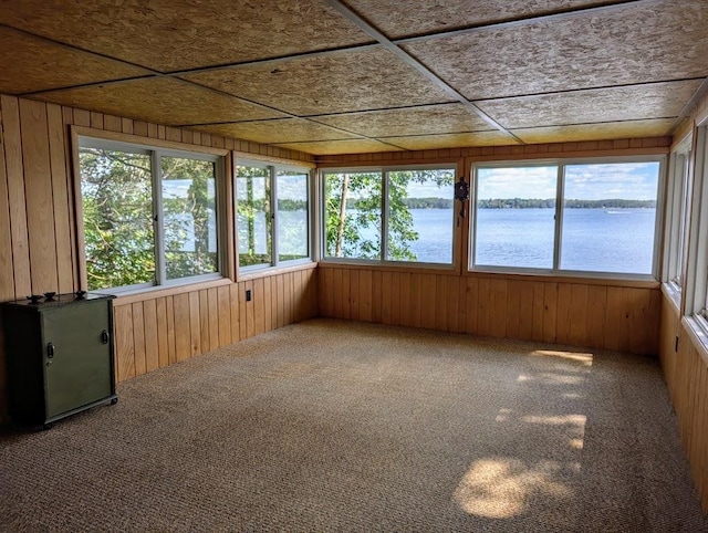 unfurnished sunroom featuring a water view