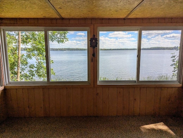 unfurnished sunroom featuring a water view