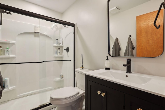 bathroom with vanity, toilet, and a shower with door