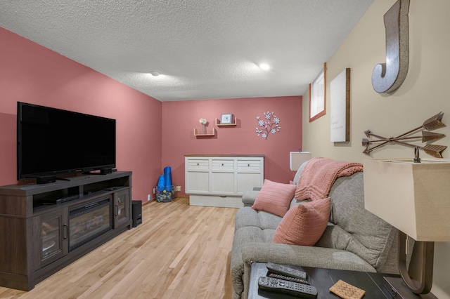 living room with a textured ceiling and light wood-type flooring