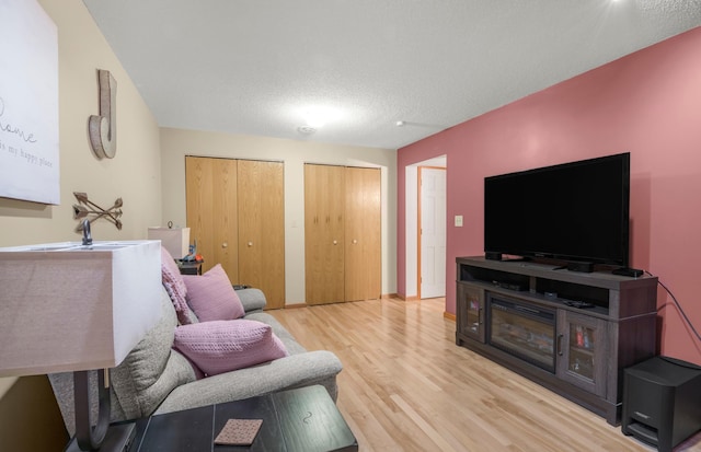 living room featuring a textured ceiling and light wood-type flooring