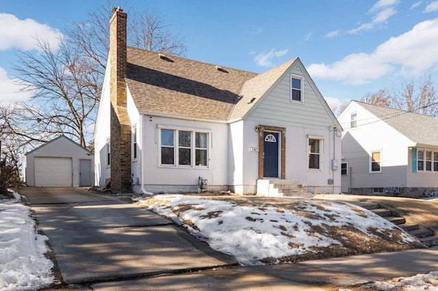 view of front of house with a garage and an outbuilding