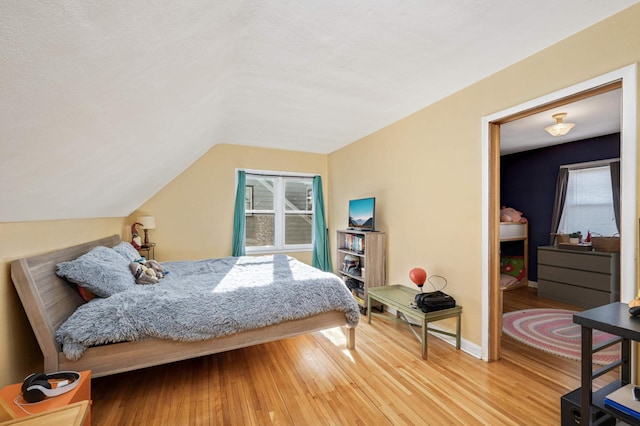 bedroom featuring wood-type flooring and vaulted ceiling