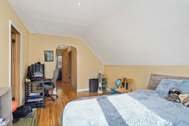 bedroom with lofted ceiling and light wood-type flooring