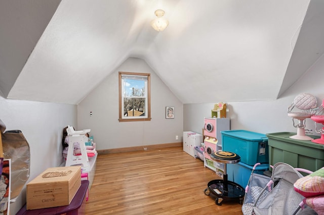 playroom featuring lofted ceiling and light hardwood / wood-style floors