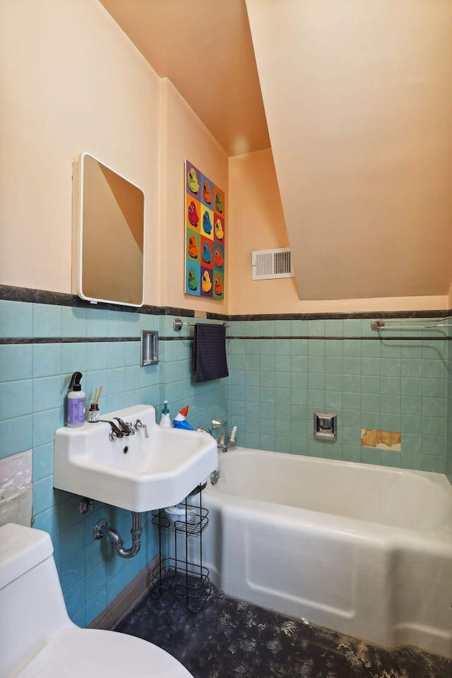 bathroom featuring toilet, sink, tile walls, and a washtub