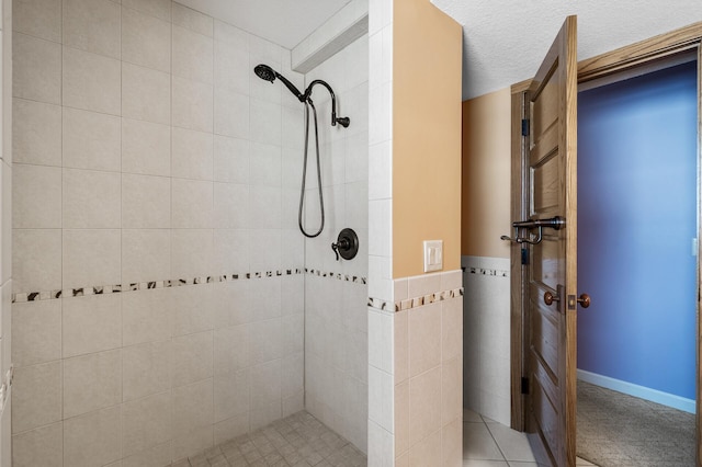 full bathroom with a textured ceiling, tiled shower, and tile walls