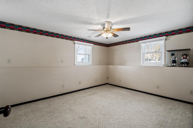 spare room featuring a ceiling fan, a textured ceiling, and baseboards