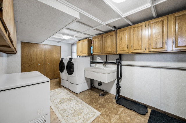 clothes washing area featuring light floors, washer and clothes dryer, a sink, and cabinet space