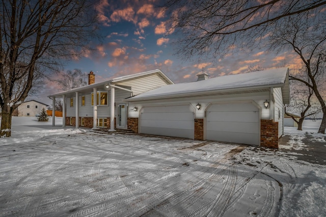 view of front of house with brick siding, a chimney, and an attached garage