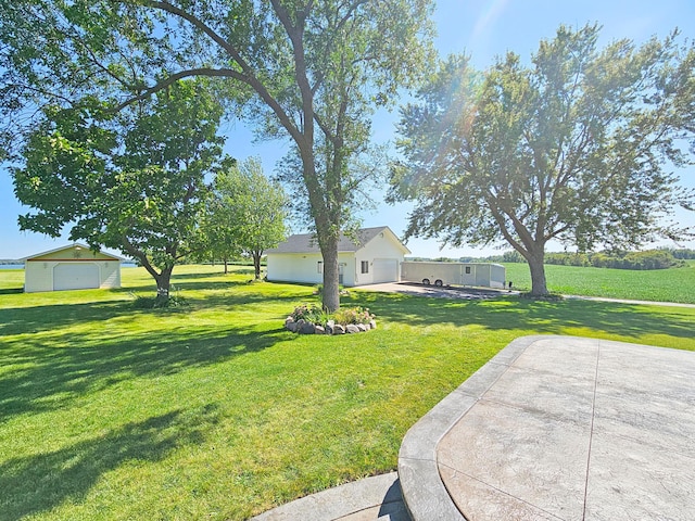 view of yard with a garage and a patio area