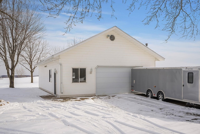 view of snow covered exterior with a garage