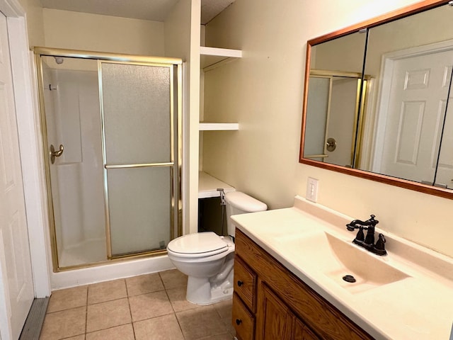 bathroom featuring tile patterned flooring, vanity, toilet, and walk in shower