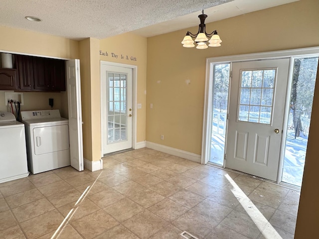 interior space with a textured ceiling, a notable chandelier, and independent washer and dryer