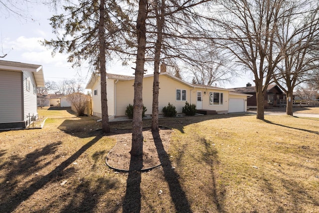 rear view of house featuring a garage and a lawn