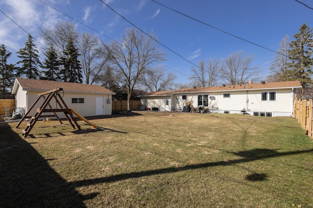 rear view of property featuring a yard and an outdoor structure