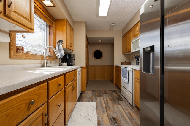 kitchen featuring dark hardwood / wood-style flooring, sink, white appliances, and a textured ceiling