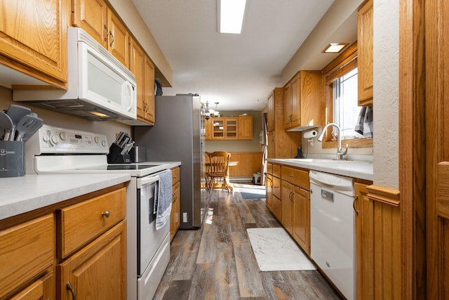 kitchen featuring white appliances, dark hardwood / wood-style floors, and sink