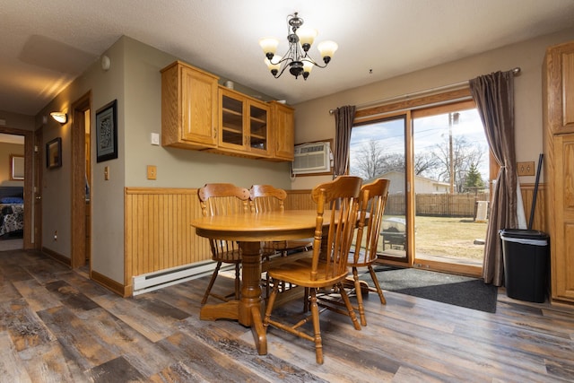 dining space with a baseboard radiator, dark hardwood / wood-style flooring, and a notable chandelier