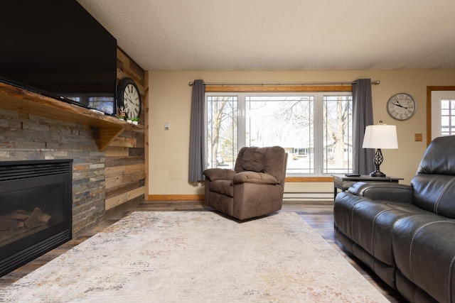 living room with hardwood / wood-style flooring, a fireplace, a baseboard radiator, and a textured ceiling