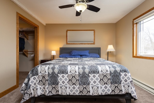 bedroom featuring a baseboard radiator, carpet floors, a walk in closet, ceiling fan, and a closet