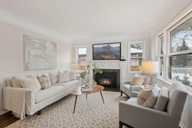 living room with ornamental molding and a tile fireplace