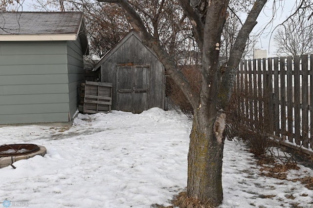 yard layered in snow with a shed