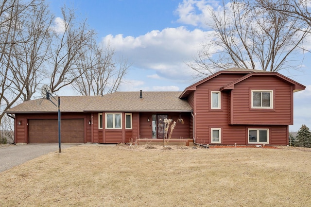 tri-level home with a garage and a front yard