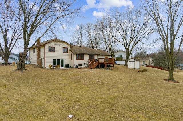 rear view of house with a storage shed, a deck, and a lawn