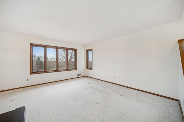 carpeted spare room with a textured ceiling